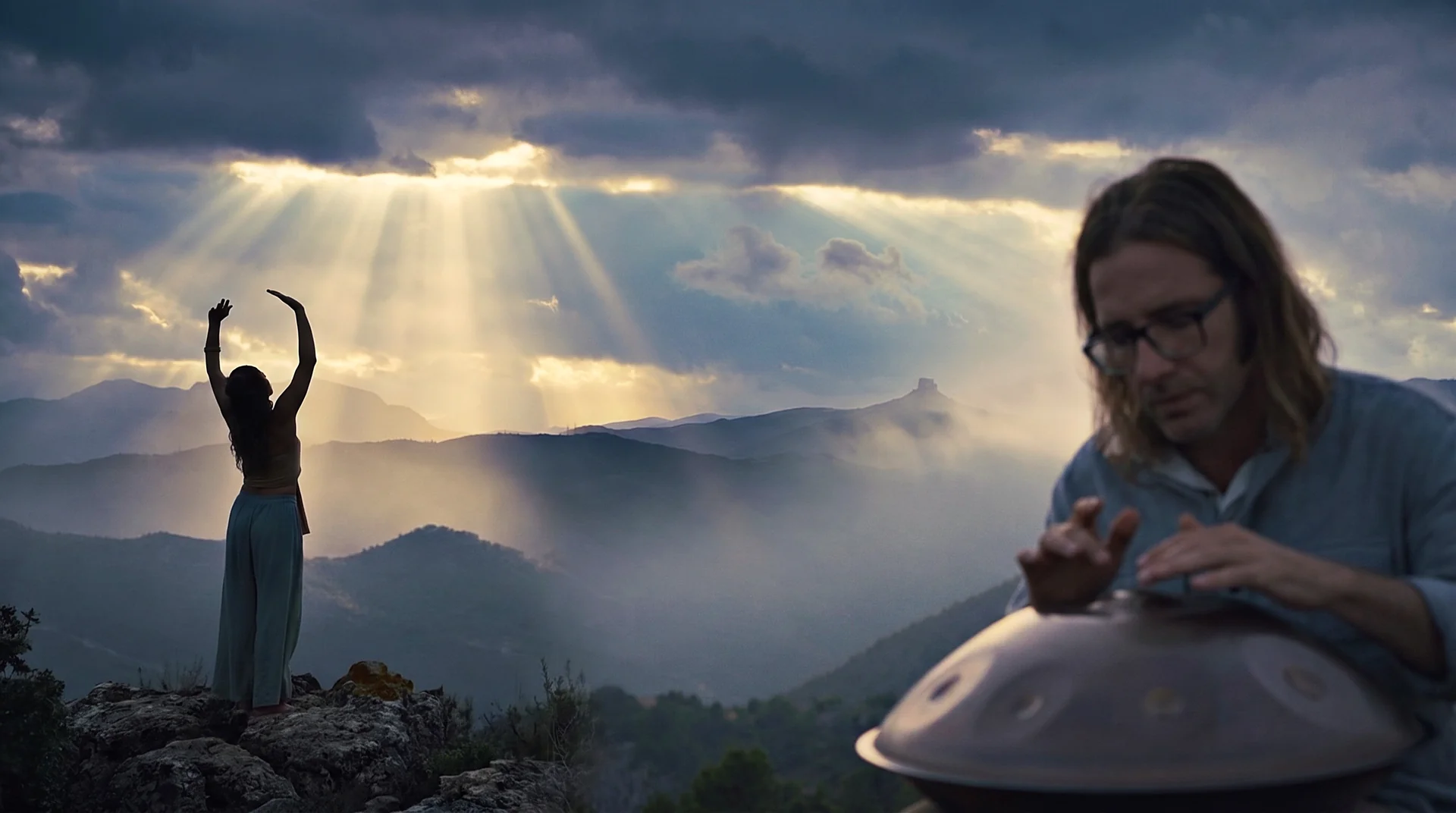Terra Cultura: handpan player and dancer on a mountain ridge at sunrise